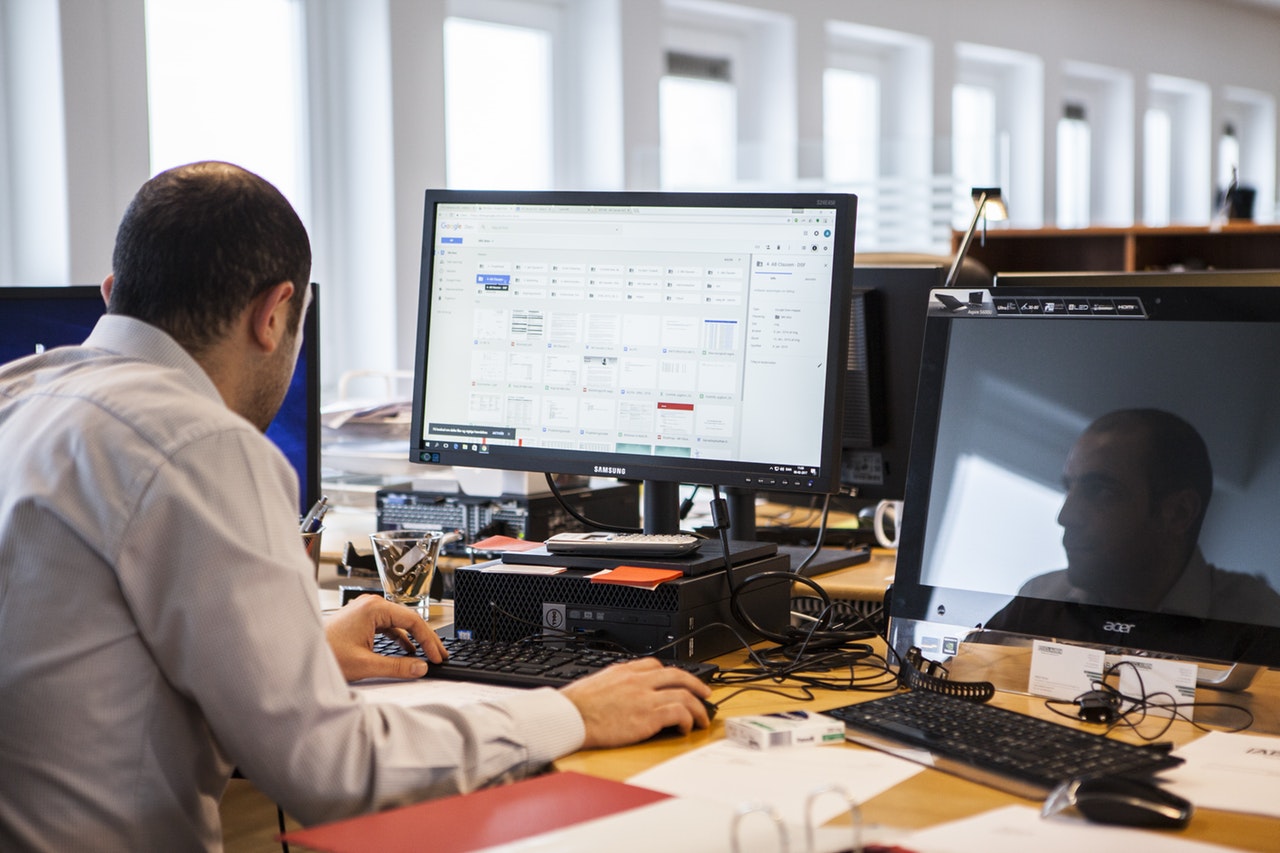 man working with two computers